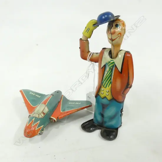 2 OLD TIN PLATE TOYS; MAN DOFFING HAT H..150 (KEY MISSING) & FIGHTER JET L. 110MM